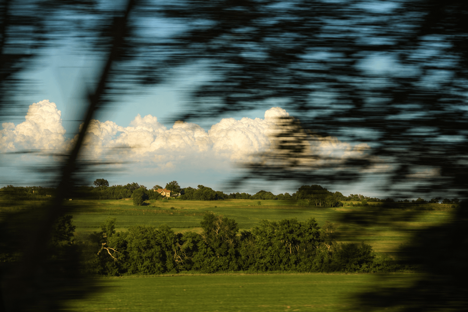 Landscape with clouds seen through a train window